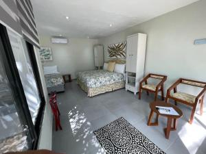 een slaapkamer met een bed en 2 stoelen en een tafel bij The Blue Eco Lodge in Valladolid