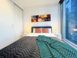 een slaapkamer met een bed en een groot raam bij Experience Melbourne in Styles in Melbourne