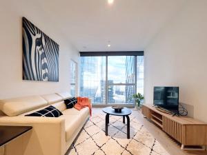 een woonkamer met een bank en een tv bij Experience Melbourne in Styles in Melbourne