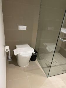 een badkamer met een toilet en een glazen douche bij Experience Melbourne in Styles in Melbourne
