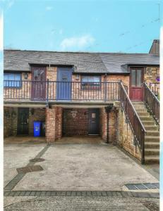 an old brick house with a balcony and stairs at The Old Bakery Seahouses in Seahouses