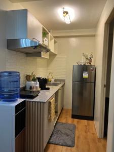 a kitchen with a refrigerator and a counter top at Micairan Suite in Davao City