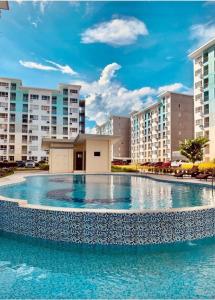 uma grande piscina em frente a alguns edifícios de apartamentos em Micairan Suite em Dávao
