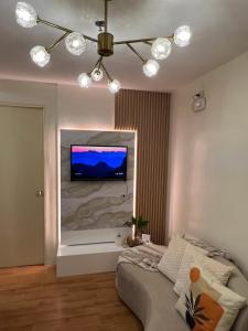 uma sala de estar com uma televisão na parede em Micairan Suite em Dávao