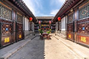 a courtyard of a building with tables and chairs at Pingyao Ji Family Courtyard Inn in Pingyao