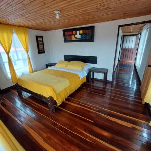 a bedroom with a bed and a wooden floor at Hotel Campestre Mirador De San Nicolas in Ubaque