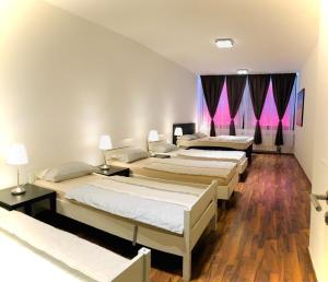three beds in a room with pink curtains at Luxury Premium Apartments in Bonn