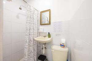 a white bathroom with a sink and a toilet at La Peregrina Galapagos B&B in Puerto Ayora