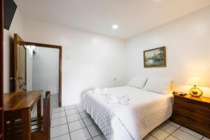 1 dormitorio con cama, mesa y escritorio en La Peregrina Galapagos B&B, en Puerto Ayora