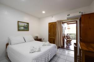 1 dormitorio con 1 cama con colcha blanca en La Peregrina Galapagos B&B, en Puerto Ayora