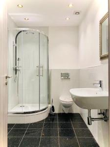 a bathroom with a shower and a sink and a toilet at Luxury Premium Apartments in Bonn