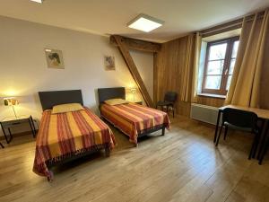een hotelkamer met 2 bedden en een raam bij La murette in Solignac