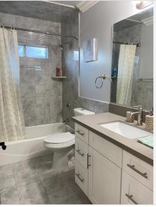 a bathroom with a toilet and a sink and a shower at New! Cozy Gated 3BR, 2BA Vacation Home in Rosemead