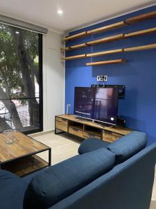 sala de estar con sofá azul y TV en Habitación privada, en Ciudad de México