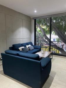 - un salon avec un canapé bleu et une table dans l'établissement Habitación privada, à Mexico