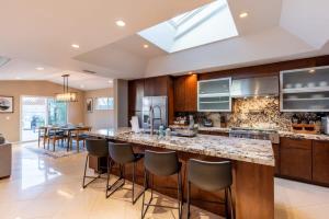 a kitchen with a large island with bar stools at Sumptuous Coastal Hideaway in Oceanside