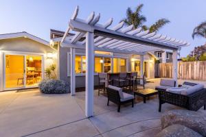 a pergola on a patio with a table and chairs at Sumptuous Coastal Hideaway in Oceanside