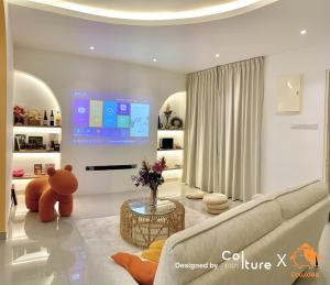 a living room with a couch and a large screen at 30-80 pax Private Event Venue - Sunset Paradise by Cowidea in Masai