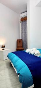 1 cama azul grande en un dormitorio con silla en Beautiful Newer Scalea Beach Apartment en Scalea
