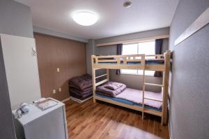 a small room with two bunk beds in it at ユースホステルソノママ in Kofu