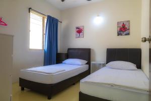 two twin beds in a room with a window at Adno Homestay Seroja#3BR#5 Single#IKEA#High Speed Wifi#5pax in Simpang Ampat