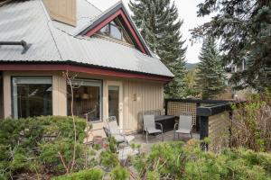 a house with a patio with chairs and a grill at The Blackcomb Ski-In Getaway in Whistler