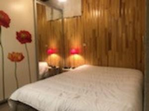 - une chambre avec un lit blanc et 2 fleurs rouges dans l'établissement Appartement Les Gets, 1 pièce, 4 personnes - FR-1-671-257, aux Gets