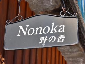 um sinal que diz nomedica pendurado num edifício em コテージ野の香 em Omachi