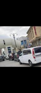 a white van parked in a parking lot with cars at Quba ALFA-M Motel in Quba