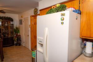 einen weißen Kühlschrank in einer Küche mit Holzschränken in der Unterkunft Spacious Comfy Room in Cozy Classy Duplex in Brooklyn