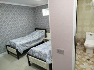 Quba ALFA-M Motel في قوبا: غرفة صغيرة بسريرين ودورة مياه
