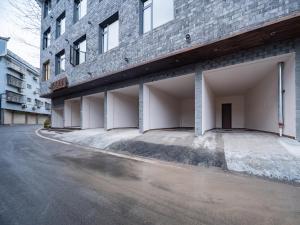 a brick building with two parking spaces next to a street at Lingxi Riverview Boutique Homestay - Phoenix Ancient Town in Fenghuang