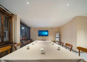 a conference room with a long table and chairs at Lingxi Riverview Boutique Homestay - Phoenix Ancient Town in Fenghuang County