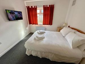 a bedroom with a bed with two towels on it at Sandy Lodge Bungalow in Boston