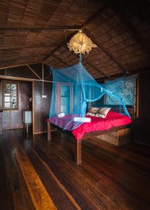 Schlafzimmer mit einem Bett mit blauem Baldachin in der Unterkunft Beachfront Hut Upstairs Astra - Beach Shack Chalet in Tioman Island