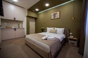 een slaapkamer met een groot bed en handdoeken bij The House Hotel Yerevan in Jerevan