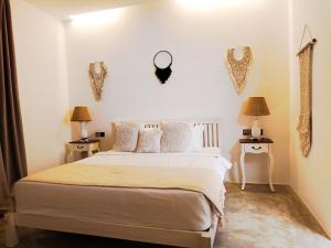 a bedroom with a bed and two tables with lamps at Omahati Villa Brawa in Dalung