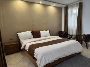 a bedroom with a large bed and a window at Road map Guest House in Addis Ababa