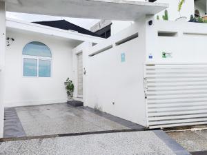 a white garage with a door and a window at Omahati Villa Brawa in Dalung