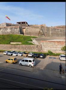 ein Parkplatz mit vor einer Mauer geparkten Autos in der Unterkunft casa castillo san felipe in Cartagena de Indias