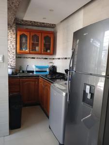 a kitchen with a stainless steel refrigerator and a dishwasher at Apartamento frente al castillo San Felipe in Cartagena de Indias