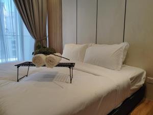 a bed with white sheets and pillows on it at Quill Residence KLCC By Ezhome in Kuala Lumpur