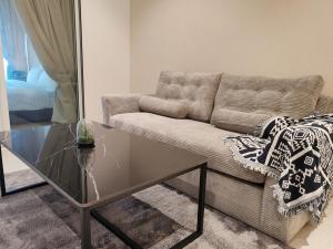 a living room with a couch and a glass coffee table at Quill Residence KLCC By Ezhome in Kuala Lumpur