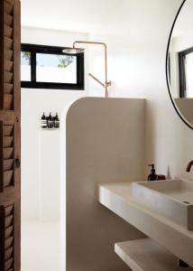 a white bathroom with a sink and a mirror at Villa Riad in Ewingsdale