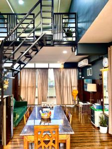 uma sala de estar com uma mesa e uma escada em The Loft House em Dimāpur