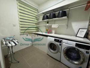 una lavanderia con lavatrice di Zayyan Guesthouse a Kuching