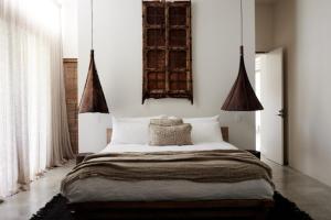 a bedroom with a large bed with white walls at Villa Riad in Ewingsdale