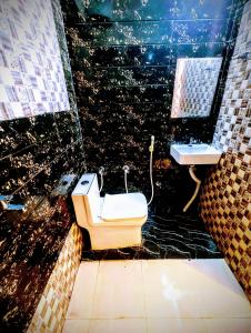 La salle de bains est pourvue de toilettes et d'un lavabo. dans l'établissement BRiJWAS DHAM, à Vrindavan