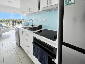 a kitchen with a sink and a stove top oven at Welcome Homestay Bayside in Larrakeyah
