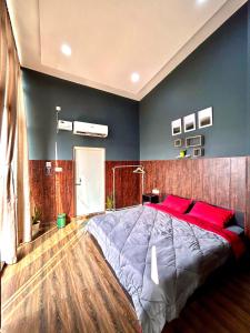 una camera da letto con un grande letto con cuscini rossi di The Loft House a Dimāpur